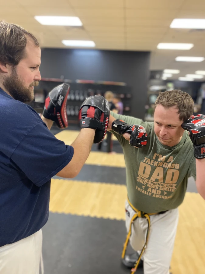 Adult martial arts students relaxing and socializing after training in Angola gym